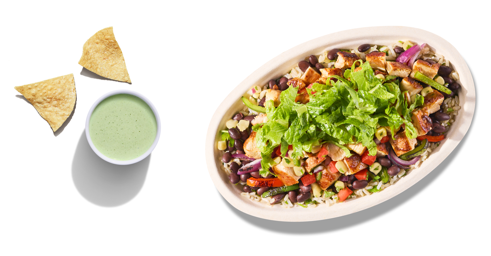A Chipotle Chicken Burrito Bowl with White Rice, Black Beans, Shredded Cheese, Fajita Peppers, Fresh Tomato Salsa, and a freshly made tortilla chip dipped in a side of our new Adobo Ranch.