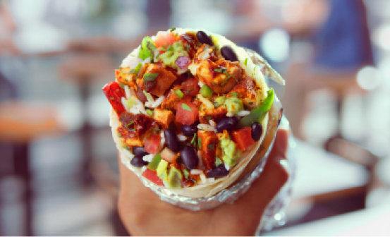 A Chipotle Burrito with black beans, fajita veggies, adobo chicken, fresh tomato salsa, monterey jack cheese, and topped with fresh guac.